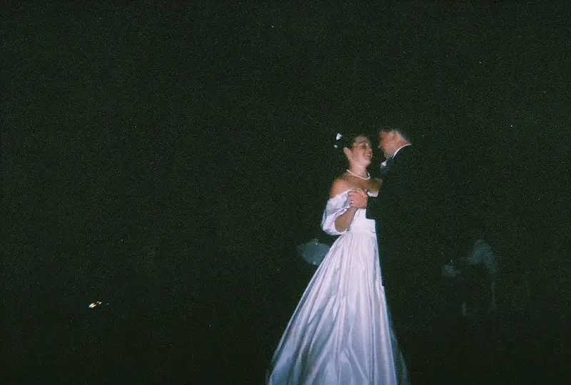 The subjects in this image by a disposable camera are too far from the camera so the flash didn't give them enough light.