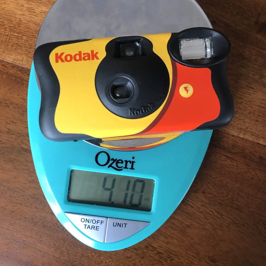 A Kodak Disposable Film camera that weighs 4.10 oz (or 116.2 g)